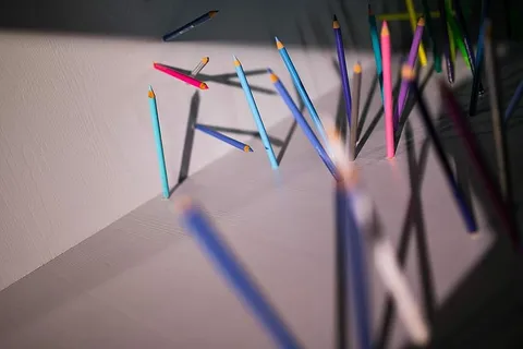 铅笔和蜡笔从墙上和地板上伸出来