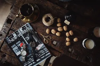 纽约人，一些坚果，手表和其他东西放在旧木桌上