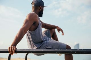 一个穿着休闲服的年轻非洲男子在健身酒吧放松