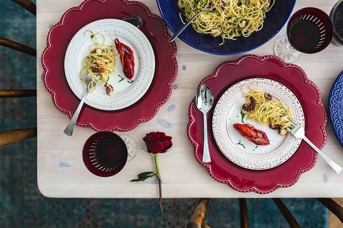 精美的晚餐，搭配海鲜意大利面、小龙虾和红酒，餐桌上装饰着玫瑰