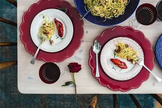 精美的晚餐，搭配海鲜意大利面、小龙虾和红酒，餐桌上装饰着玫瑰