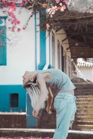 在房子旁边弯腰的女人