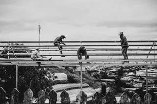 工人在脚手架上工作的灰度照片