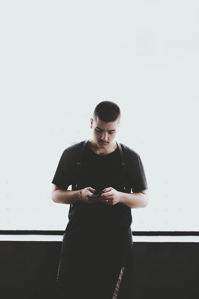 一名身穿黑色衬衫手持智能手机的男子