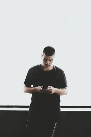 一名身穿黑色衬衫手持智能手机的男子