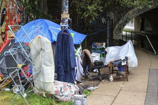 工业区运河岸边的帐篷和其他家用物品表明无家可归。