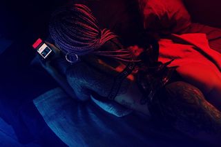 躺在床上拿着电话的女人