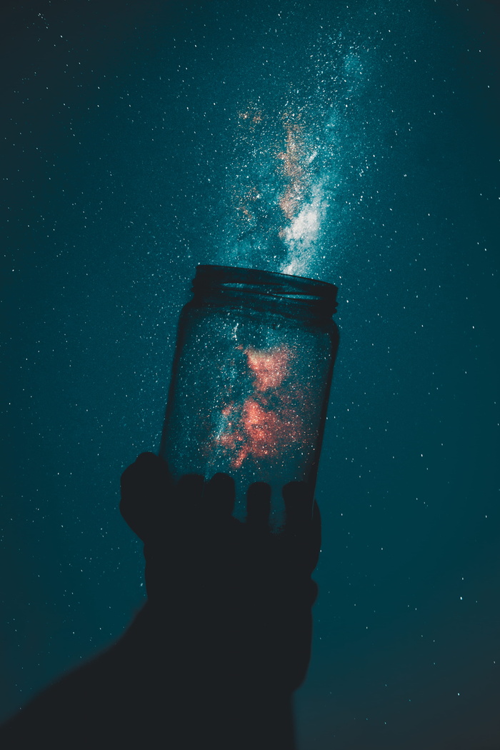 拿着玻璃泥瓦匠罐的人的剪影