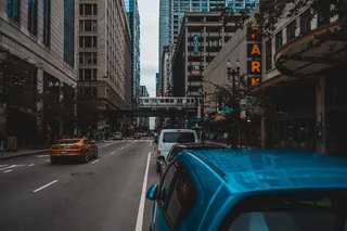 混凝土建筑物附近混凝土道路上的蓝色汽车