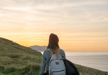 背着背包站在悬崖上的女人 背着背包站在悬崖上的女人