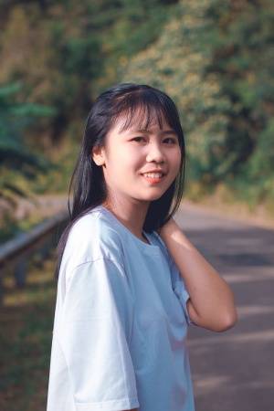 女式白色圆领T恤，手放在脖子上