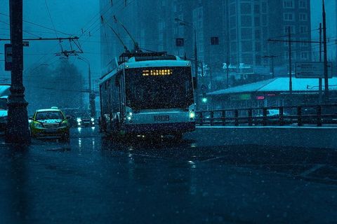 城市下雨时，公共汽车和灰色汽车在路上行驶