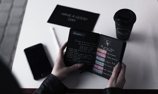 靠在白色桌子上看书的人