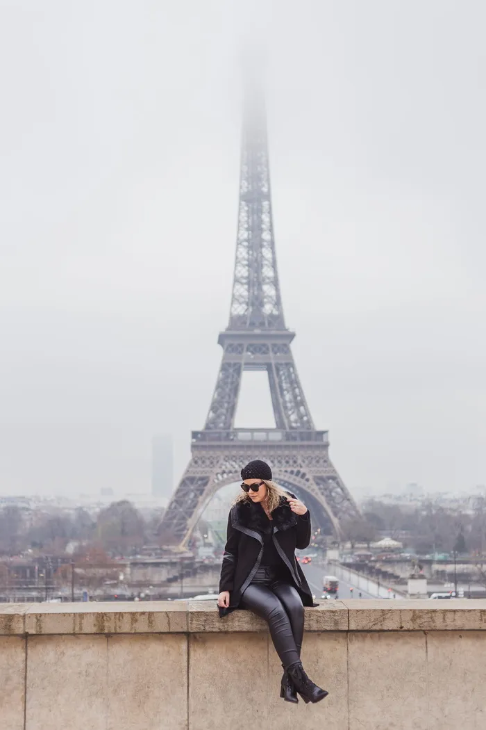 坐在棕色水泥墙上的女人