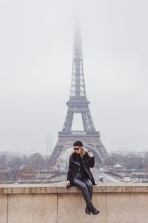 坐在棕色水泥墙上的女人