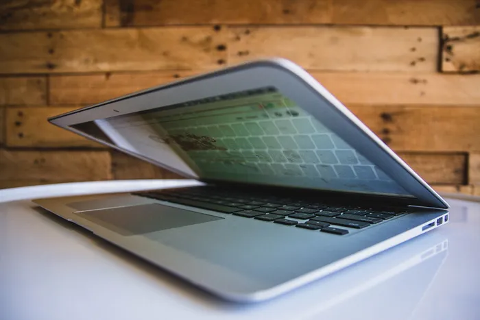 棕色墙壁附近白色表面上的MacBook电脑