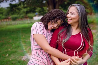 穿着粉红色连衣裙的女人拥抱另一个女人