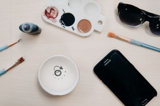 黑色三星Galaxy Android智能手机的平放照片，靠近三个蓝色画笔