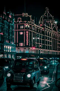 黑色出租车在夜间通过哈罗德购物中心 黑色出租车在夜间通过哈罗德购物中心