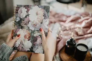 躺在床上的笔记本上写东西，里面有咖啡、蜡烛和姜饼