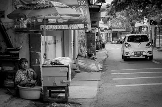 灰度照片中坐在食品摊旁的女人