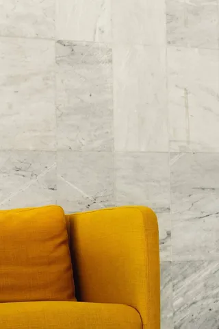 靠近灰墙的黄色沙发