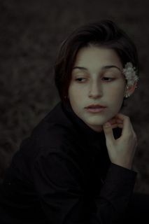 穿着黑色圆领长袖衬衫的女士坐在那里，看着自己的右侧