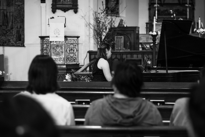 坐在教堂长椅上的人的灰度照片