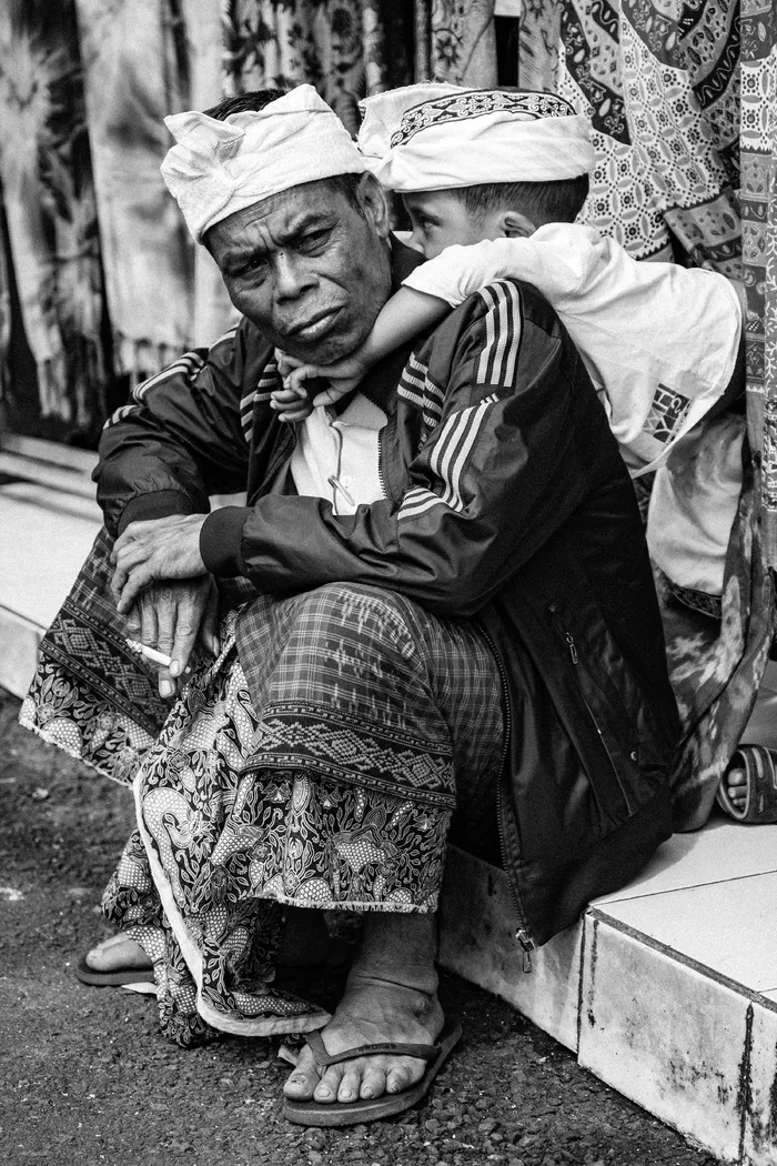 男子坐在瓷砖地板上的灰度照片