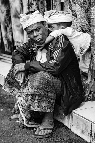 男子坐在瓷砖地板上的灰度照片