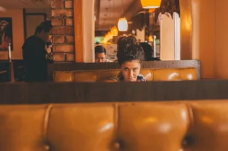 坐在建筑物内长椅中间的女性的选择性聚焦摄影