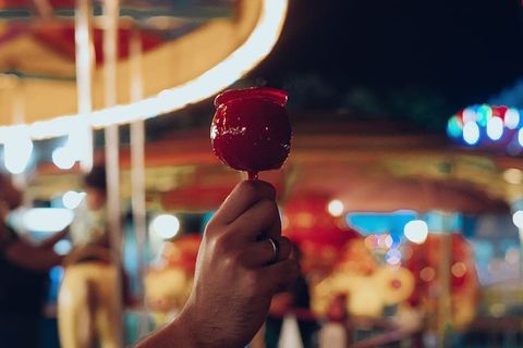 一个人在主题公园里拿着红色冰棒