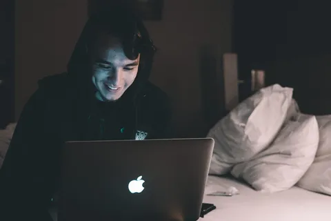 在床上使用MacBook的人 在床上使用MacBook的人