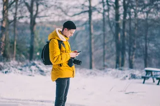 穿着棕色夹克的男子正在使用智能手机
