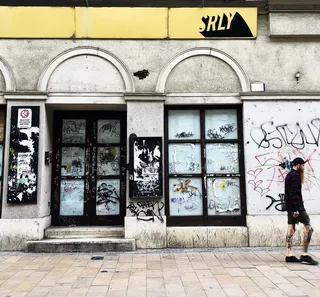 走在白色和灰色房子旁边的女人