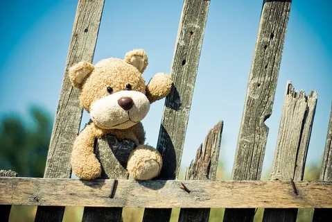 棕色木栅栏上的棕色泰迪熊