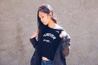 拿着黑色牛仔夹克往下看的女人