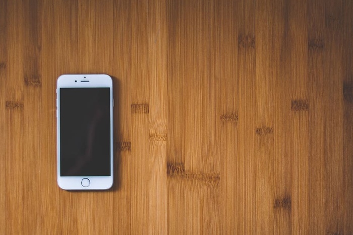 棕色木质表面的银色Iphone 6