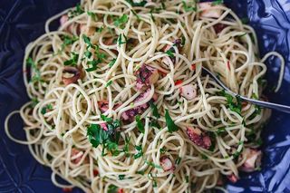 精美的晚餐，搭配海鲜意大利面、小龙虾和红酒，餐桌上装饰着玫瑰