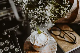 咖啡装在一个装饰性的杯子里，上面有金色的装饰物