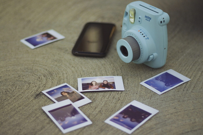 打印照片旁的白色富士胶片Instax迷你相机