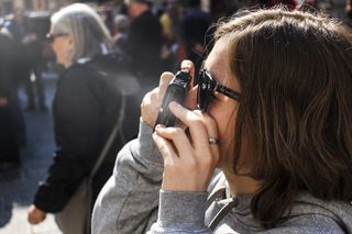 穿着灰色夹克的女人拿着相机拍照