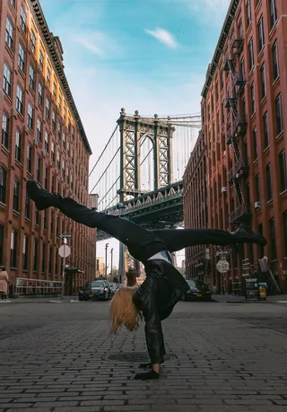 穿黑裤子和黑皮夹克的女人在路上做手站