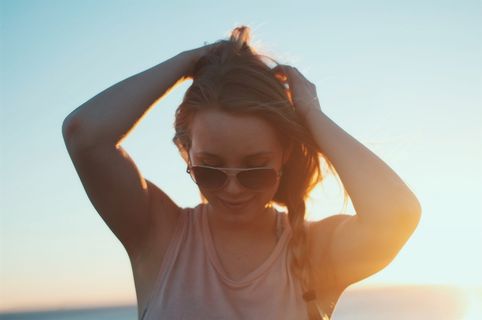 日出时穿着米色背心的女人