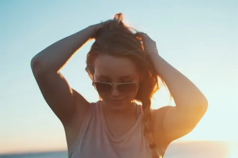 日出时穿着米色背心的女人