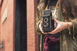 身穿绿色拉链连帽衫、手持Rediflex摄像头的女士