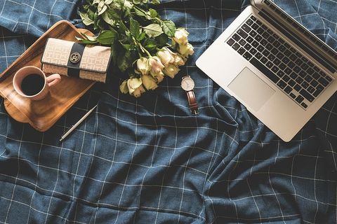 MacBook Pro、钱包、手表、咖啡、托盘和花束的平面摄影