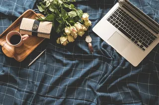 MacBook Pro、钱包、手表、咖啡、托盘和花束的平面摄影