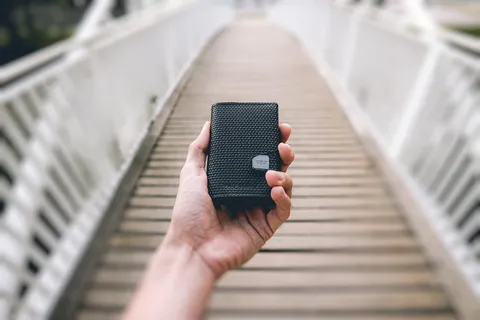 手持黑色便携式扬声器的人