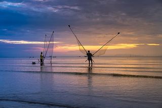 两名男子在海里拿着网的照片